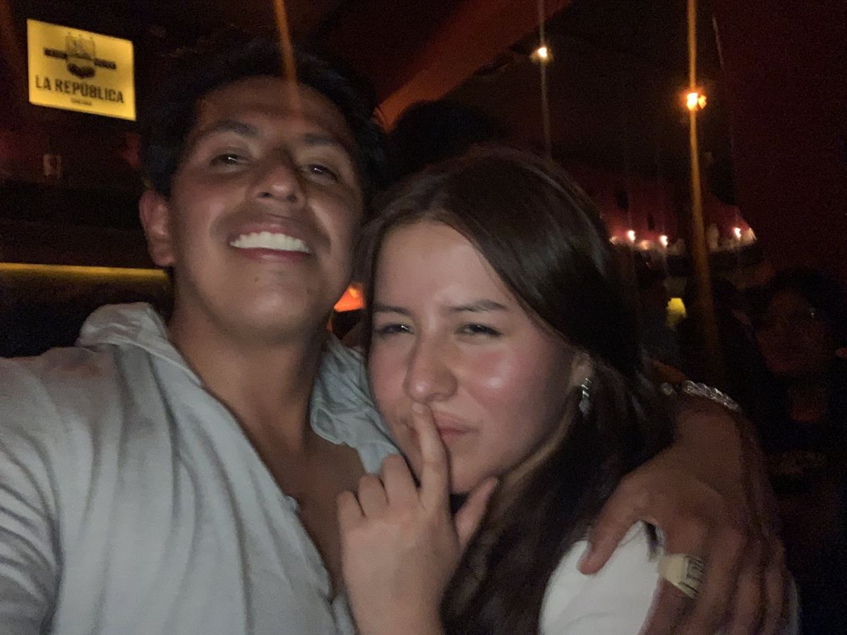 Dos personas abrazadas en una calle de noche, después de salir de un local.
