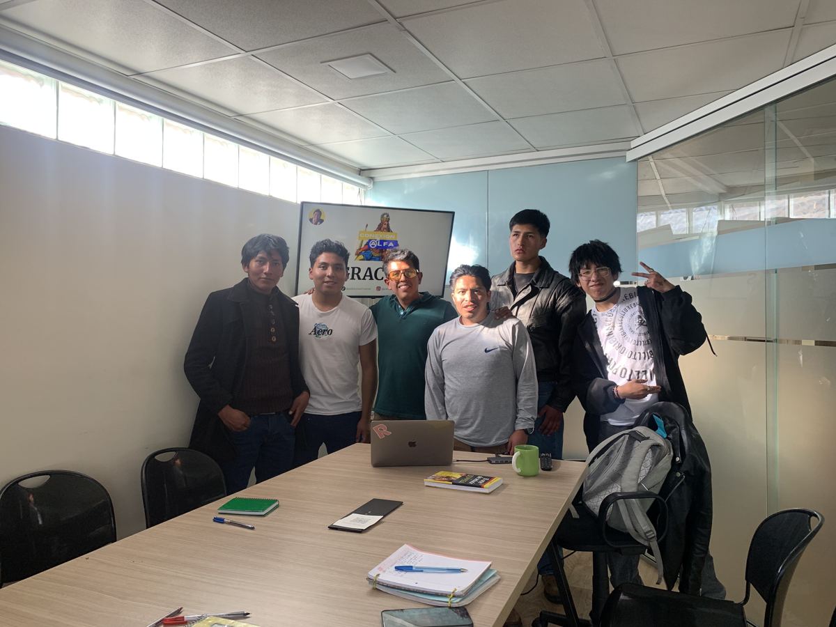 Seis hombres de pie al final de un taller de Pablo Montes, frente a una pantalla que dice Gracias.