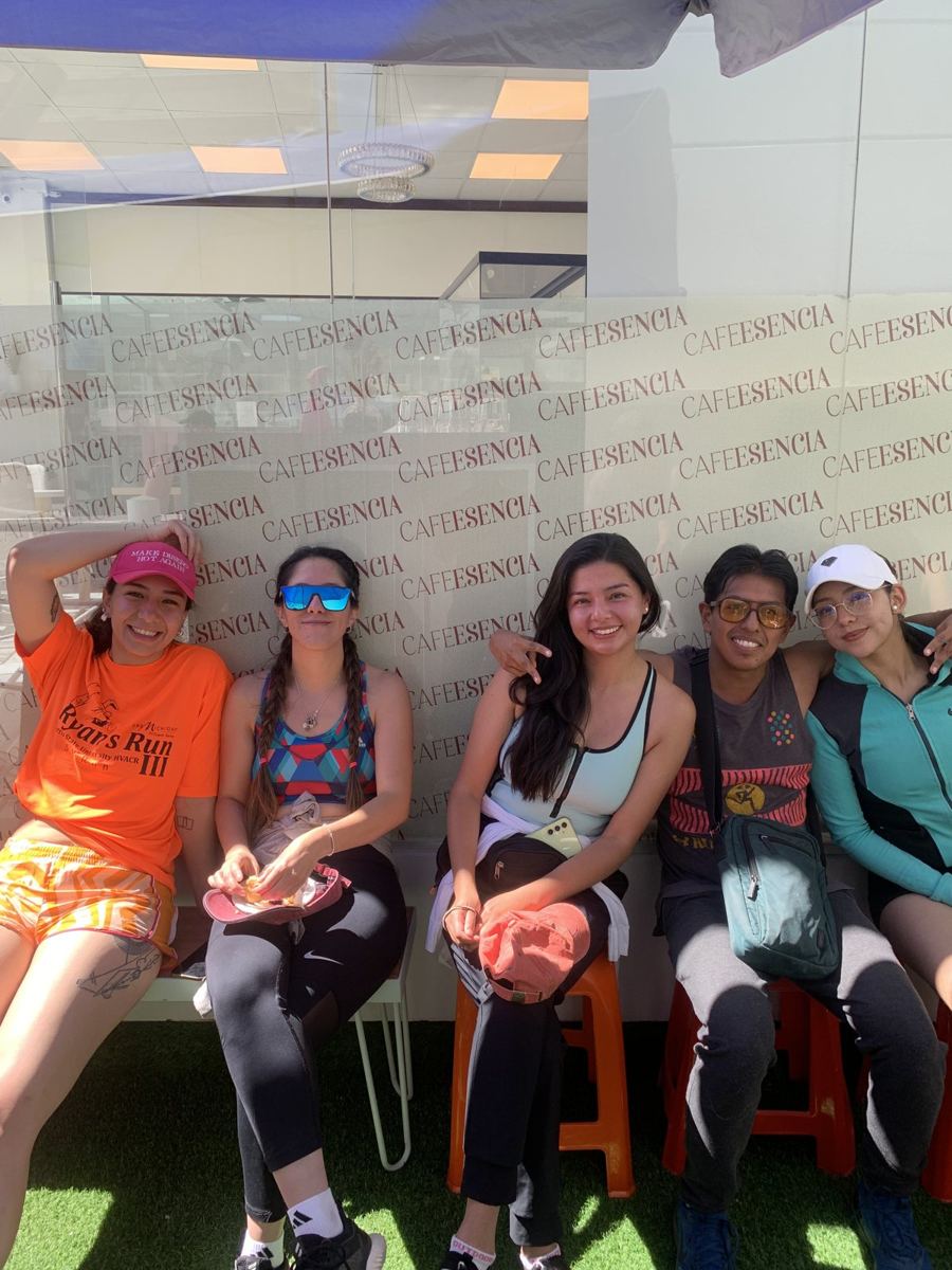 Cinco personas en ropa deportiva sentadas al sol en la terraza de un café, después de una carrera. Pablo Montes está entre ellas.